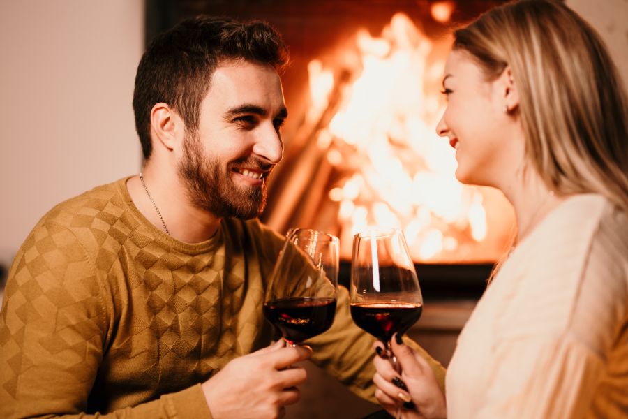 having a glass of wine by the fireplace